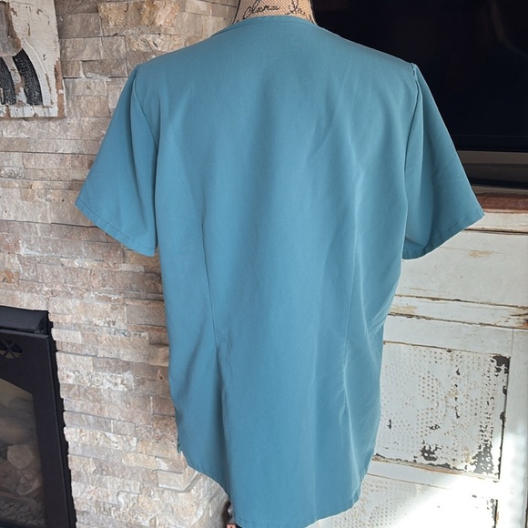 FIGS v-neck short sleeve two front pocket scrub shirt in a blue green color - Picture 9 of 16